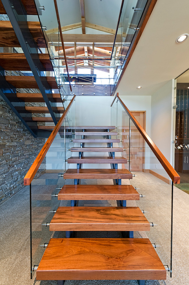 На фото: большая п-образная лестница в стиле рустика с деревянными ступенями и стеклянными перилами без подступенок