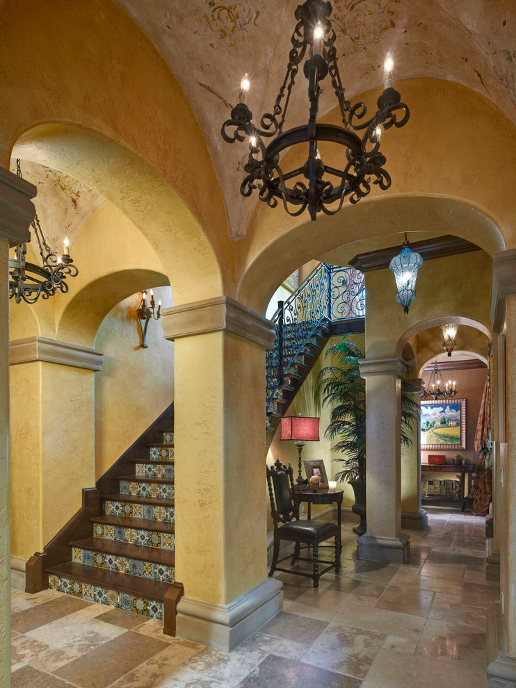 Inspiration for a large mediterranean wooden u-shaped staircase remodel in Orlando with tile risers