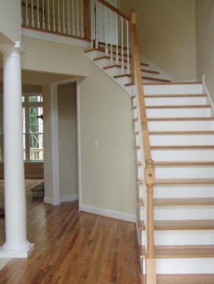 Modelo de escalera curva clásica de tamaño medio con escalones de madera y contrahuellas de madera pintada