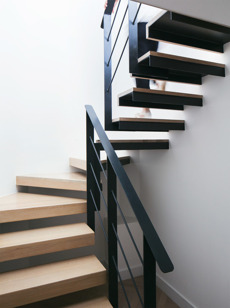 Design ideas for a large modern wood floating staircase in London with open risers.