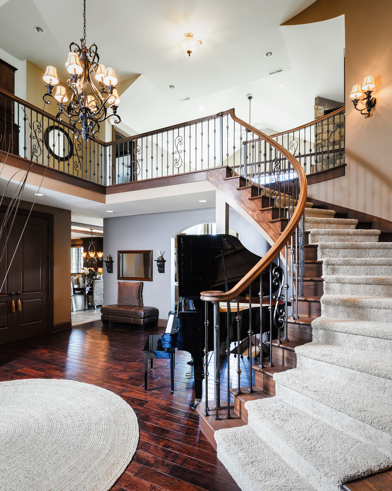 Design ideas for a large traditional carpeted curved staircase in Grand Rapids with carpeted risers and feature lighting.