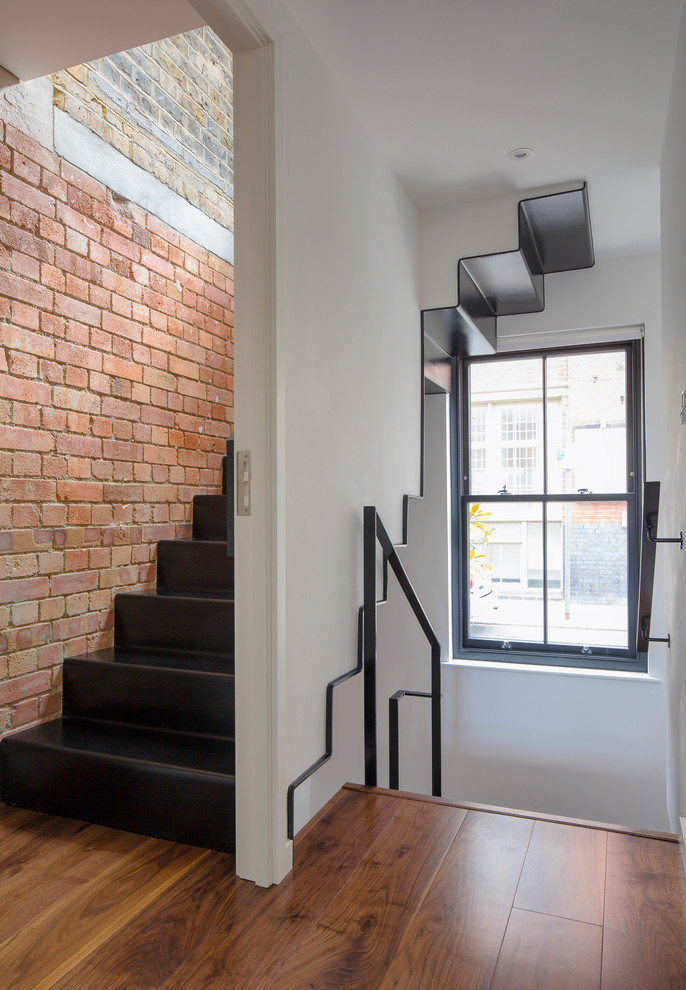 Industrial metal l-shaped staircase in London with metal risers.