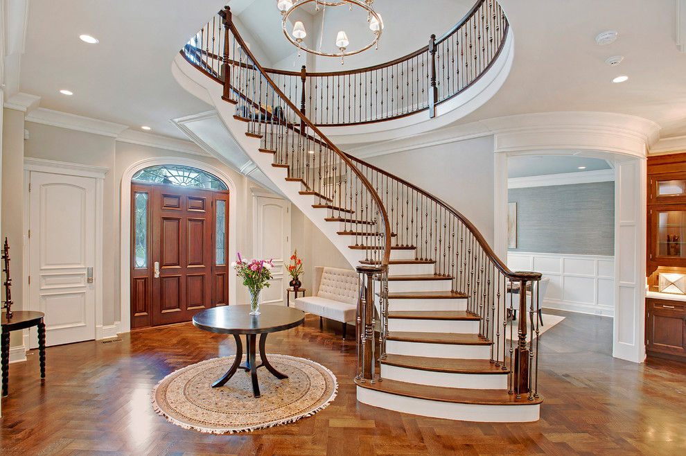 Staircase - large traditional wooden curved metal railing staircase idea in Chicago with painted risers