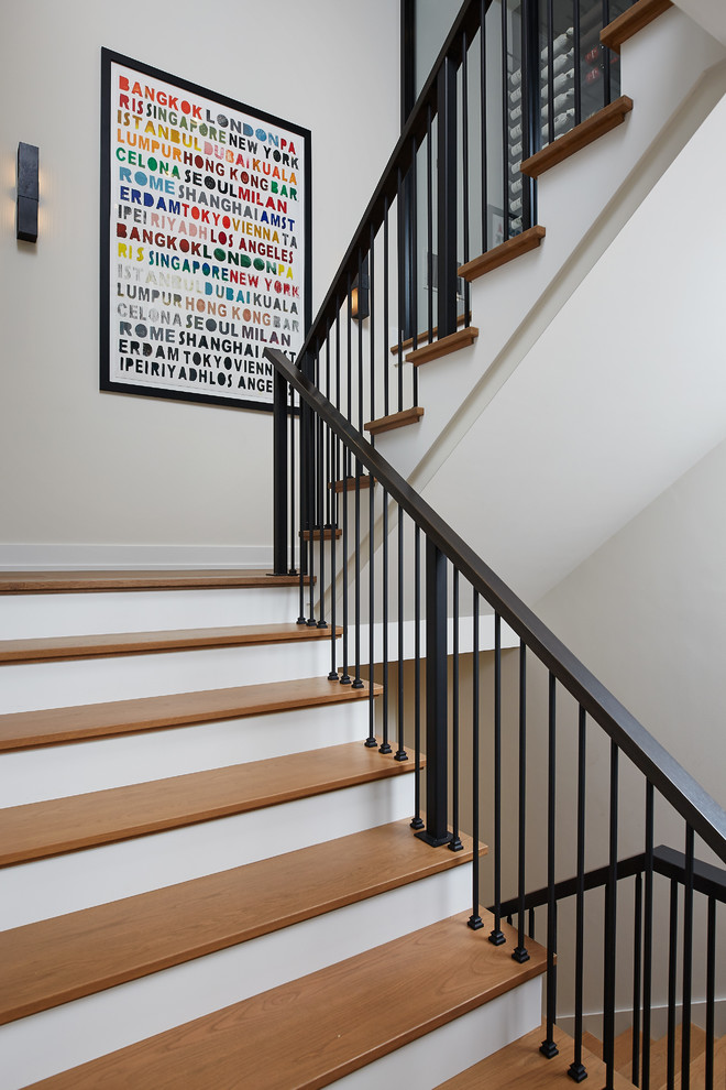 Diseño de escalera en U contemporánea grande con escalones de madera, contrahuellas de madera y barandilla de metal