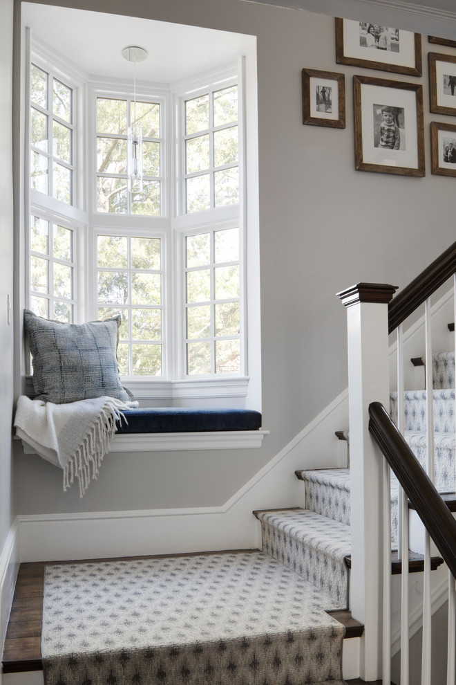 Ejemplo de escalera en L clásica renovada de tamaño medio con escalones de madera, contrahuellas de madera pintada y barandilla de madera