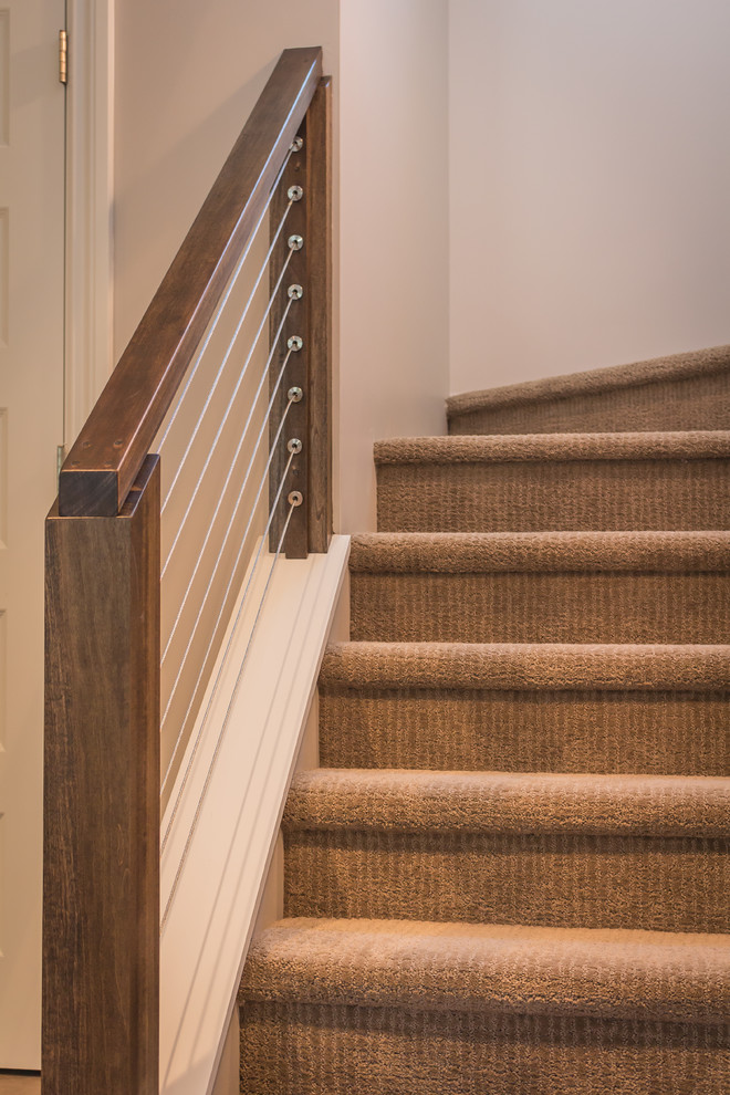 This is an example of a small classic carpeted u-shaped wire cable railing staircase in Detroit with carpeted risers.