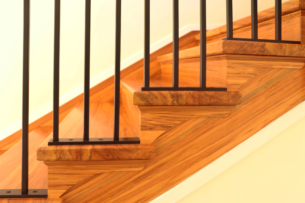 Modelo de escalera en L tradicional de tamaño medio con escalones de madera, contrahuellas de madera y barandilla de metal