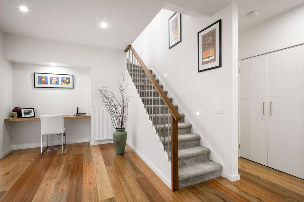 Staircase - mid-sized modern carpeted l-shaped wood railing staircase idea in Melbourne with carpeted risers