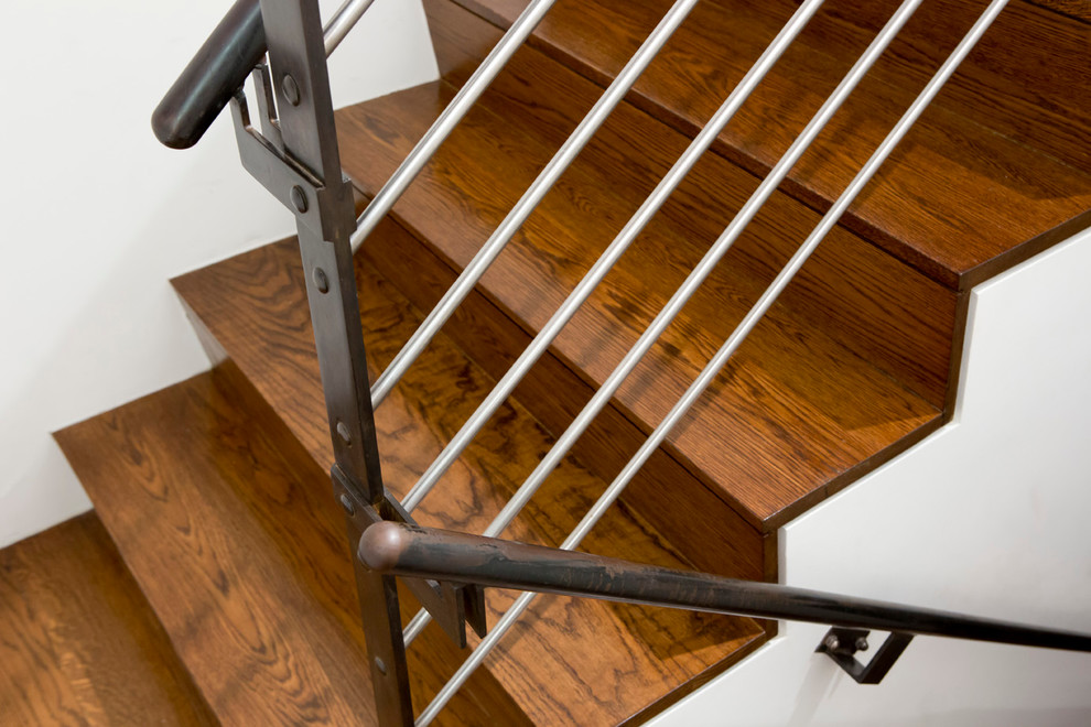 Imagen de escalera en U contemporánea de tamaño medio con escalones de madera, contrahuellas de madera y barandilla de metal