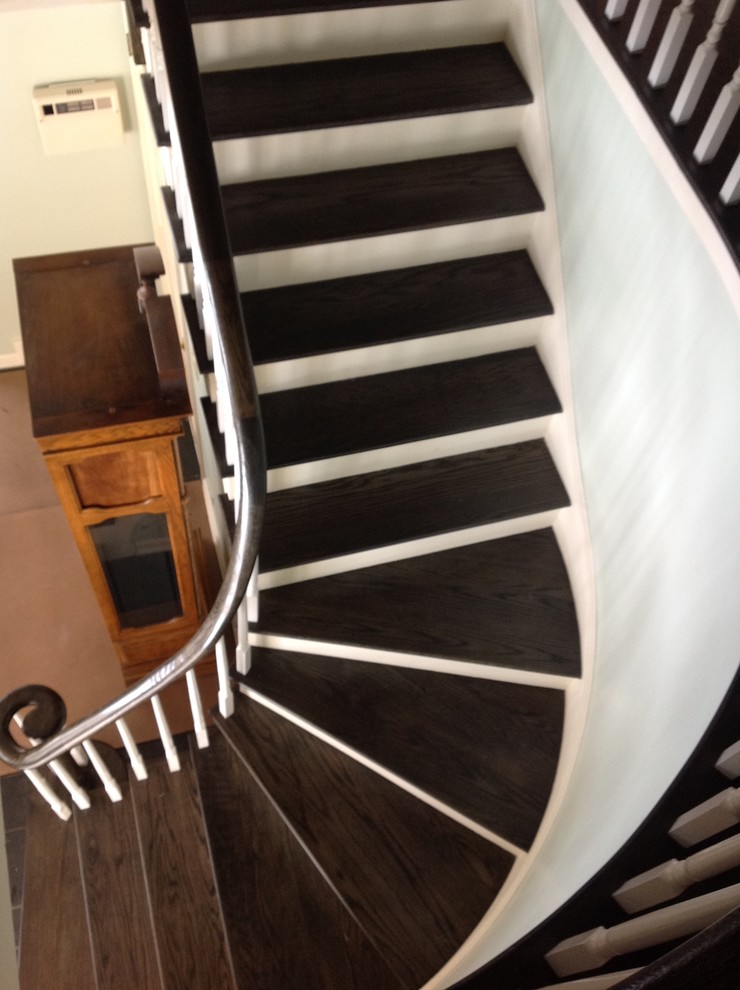 Aménagement d'un escalier peint courbe moderne de taille moyenne avec des marches en bois et un garde-corps en bois.