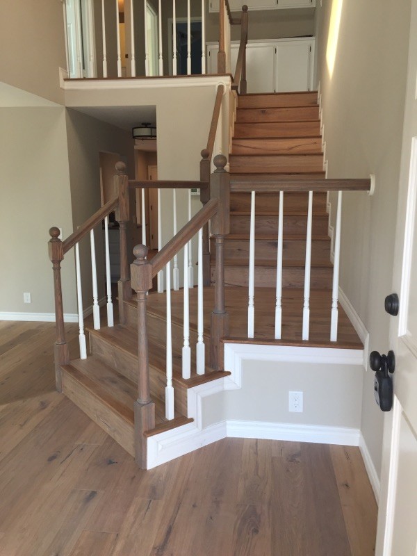 Ejemplo de escalera en L de estilo americano de tamaño medio con escalones de madera, contrahuellas de madera y barandilla de madera