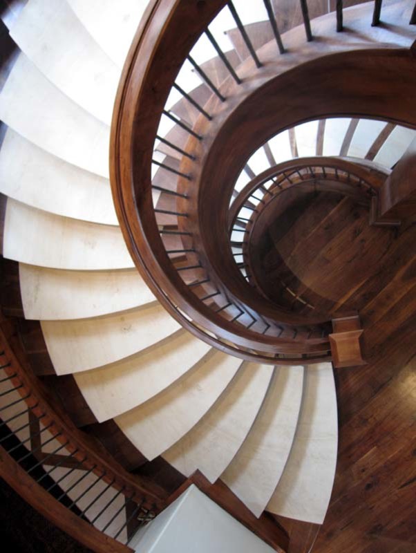Стильный дизайн: огромная изогнутая деревянная лестница в классическом стиле с ступенями с ковровым покрытием - последний тренд