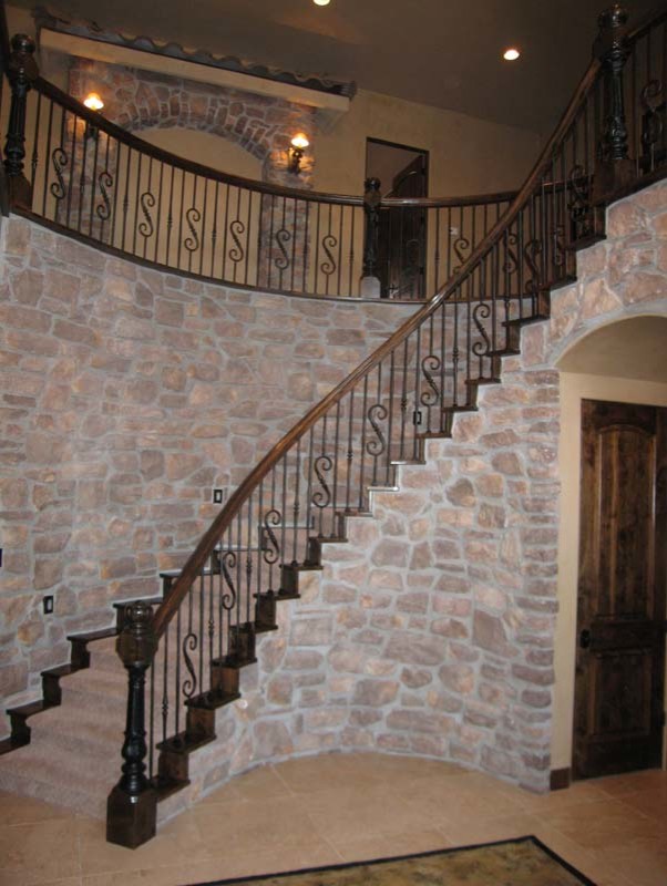 Пример оригинального дизайна: большая изогнутая лестница в классическом стиле с ступенями с ковровым покрытием и ковровыми подступенками