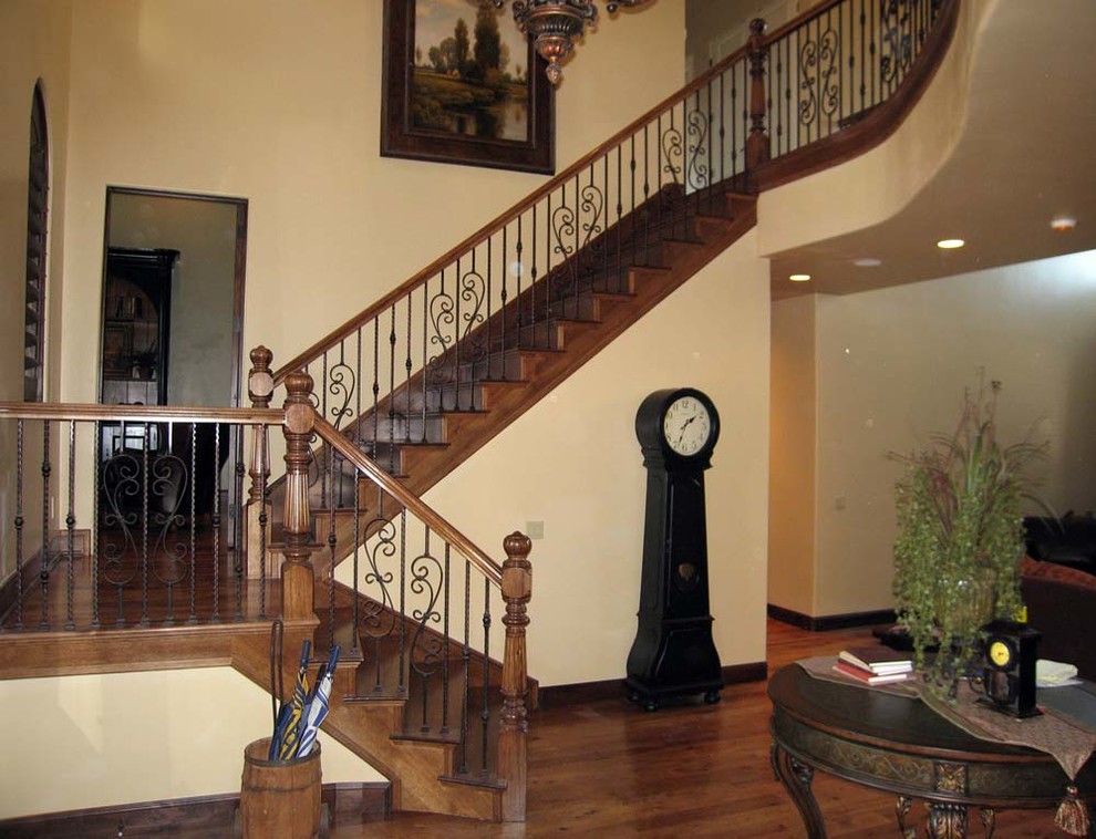 Cette photo montre un grand escalier chic en U avec des marches en bois et des contremarches en bois.