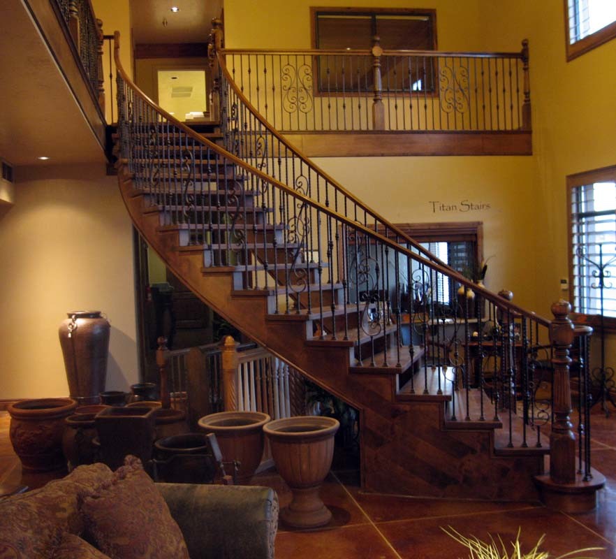 На фото: большая изогнутая лестница в классическом стиле с деревянными ступенями без подступенок с