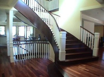 Foto de escalera curva contemporánea grande con escalones de madera, contrahuellas de madera y barandilla de madera