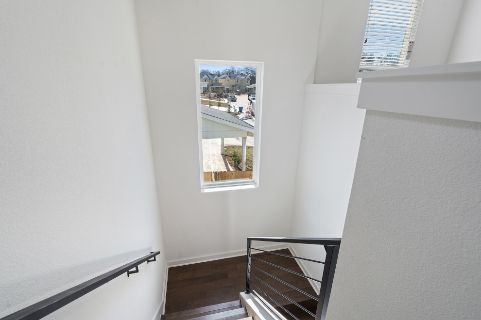 Idée de décoration pour un escalier minimaliste en U de taille moyenne avec des marches en bois, des contremarches en bois et un garde-corps en métal.