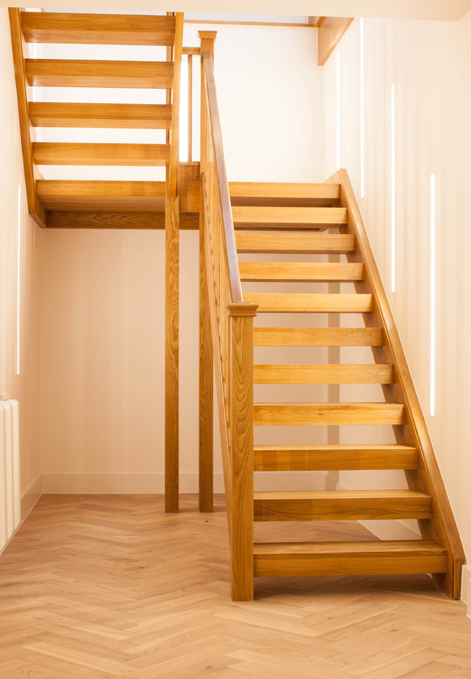 Immagine di una scala a "U" contemporanea con pedata in legno, alzata in legno e parapetto in legno