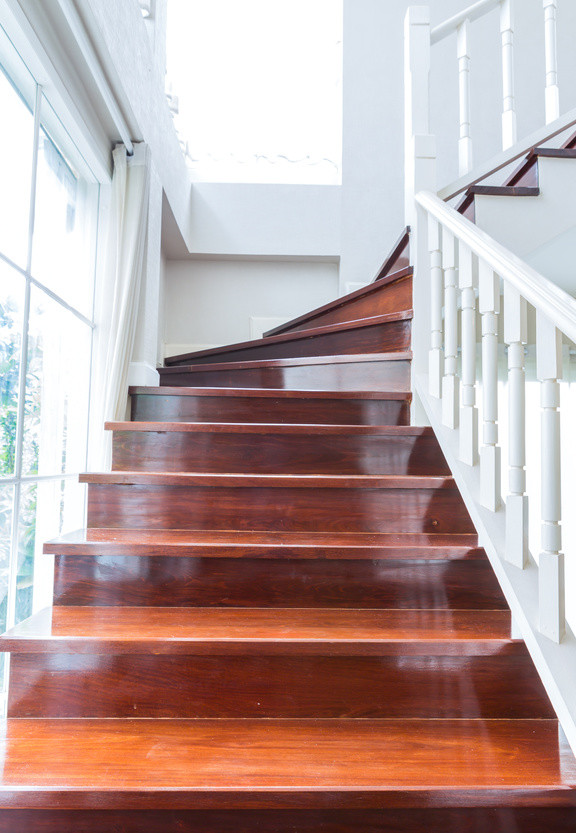 Diseño de escalera curva grande con escalones de madera y contrahuellas de madera