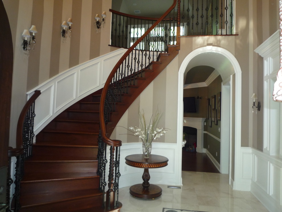 Staircase - large traditional wooden curved staircase idea in New York with wooden risers