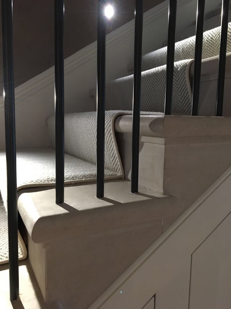 Imagen de escalera recta tradicional grande con escalones de mármol, contrahuellas de mármol y barandilla de metal