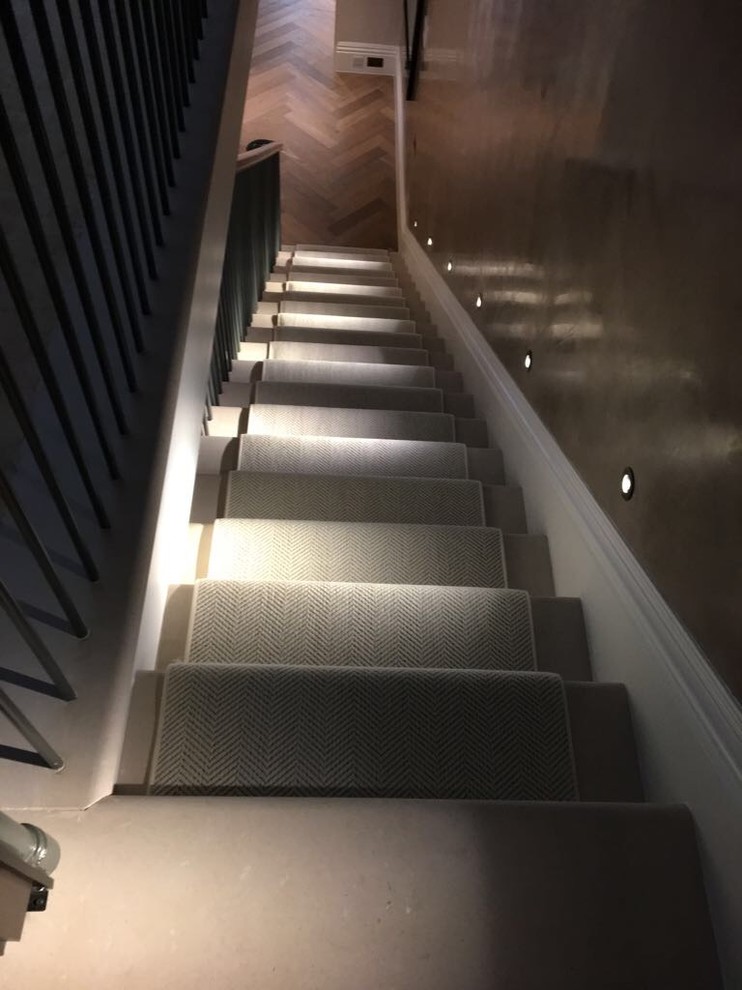 Large classic straight metal railing staircase in London with marble treads and marble risers.