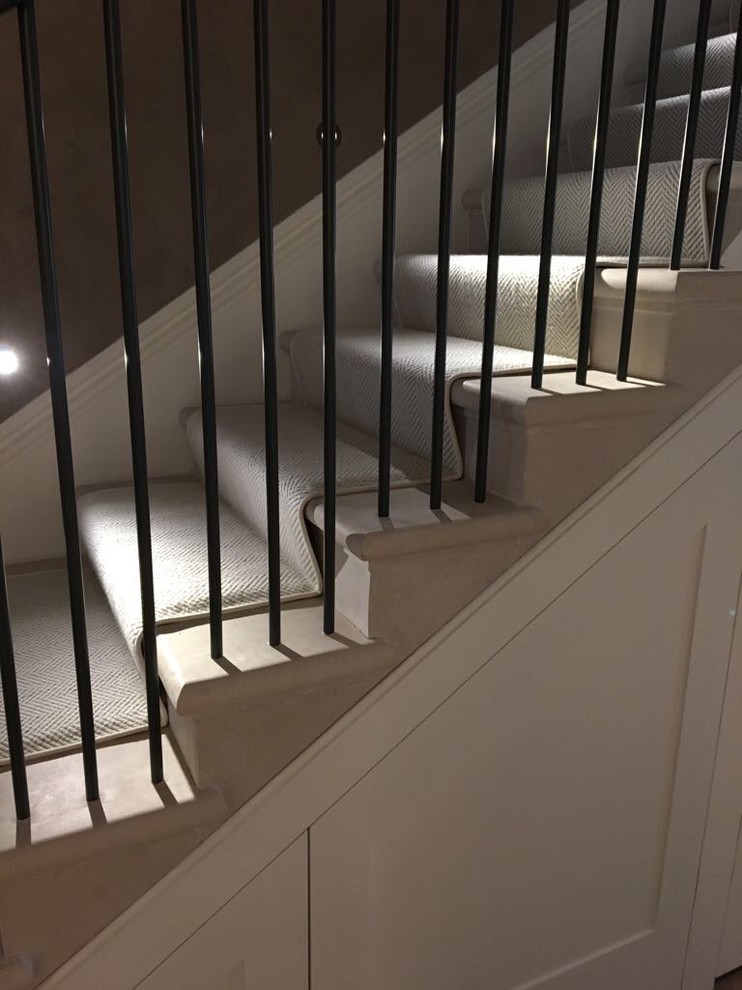 ロンドンにある高級な広いトラディショナルスタイルのおしゃれな直階段 (大理石の蹴込み板、金属の手すり) の写真