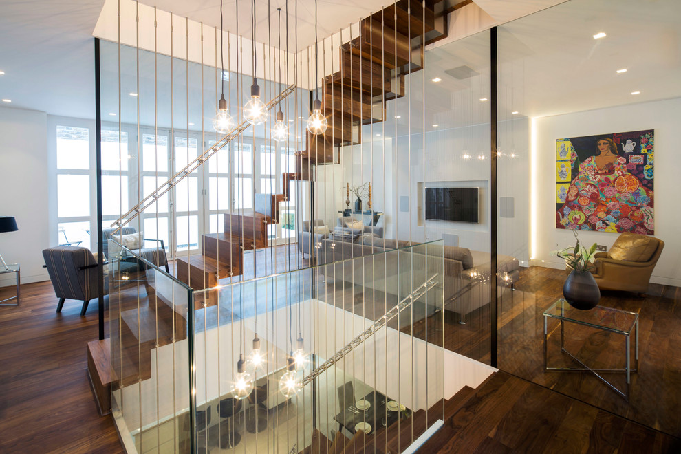Diseño de escalera recta minimalista grande con escalones de madera, contrahuellas de madera y barandilla de metal