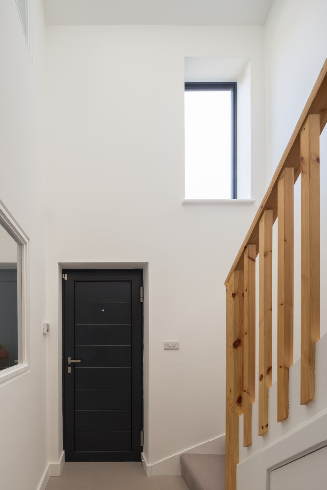 Inspiration for a medium sized contemporary carpeted l-shaped wood railing staircase in Cambridgeshire with carpeted risers.
