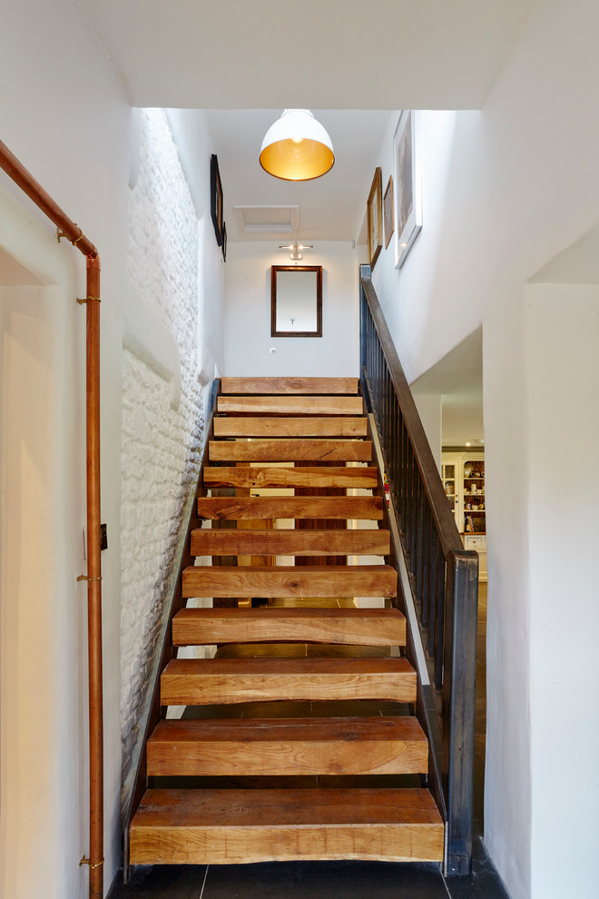 На фото: прямая лестница среднего размера в стиле кантри с деревянными ступенями без подступенок с