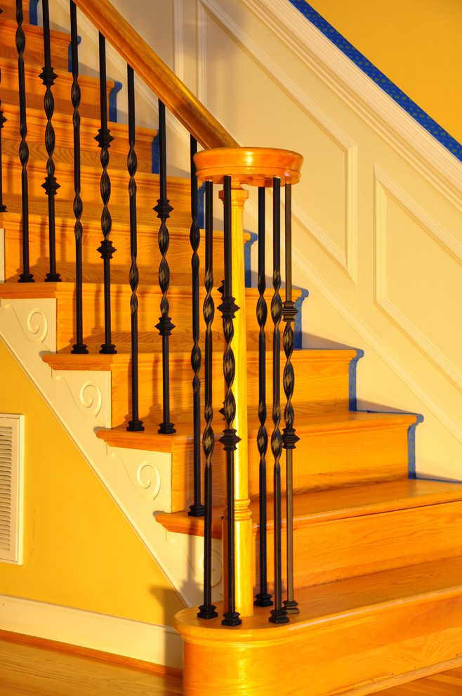Ejemplo de escalera en L clásica de tamaño medio con escalones de madera, contrahuellas de madera pintada y barandilla de varios materiales