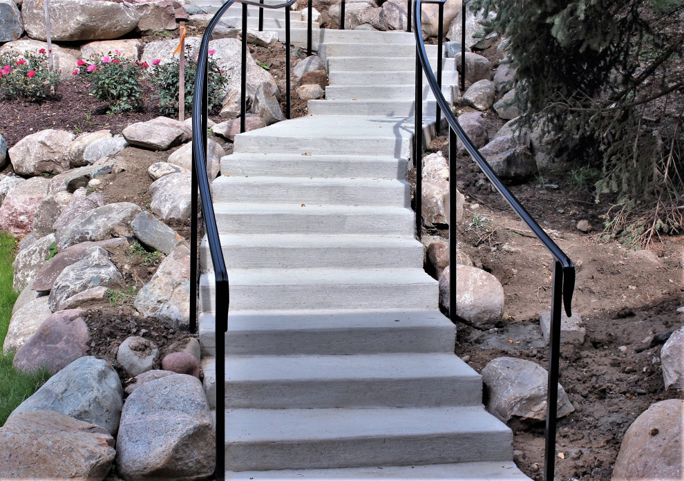 Inspiration for a mid-sized transitional concrete curved metal railing staircase remodel in Detroit with concrete risers