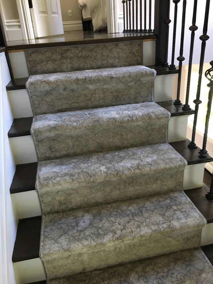 Cette image montre un escalier traditionnel en L de taille moyenne avec des marches en moquette, des contremarches en moquette et un garde-corps en matériaux mixtes.