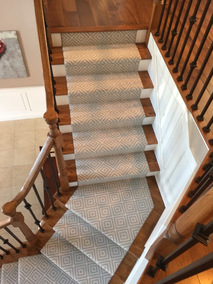 Ejemplo de escalera curva contemporánea de tamaño medio con escalones de madera, contrahuellas de madera pintada y barandilla de madera
