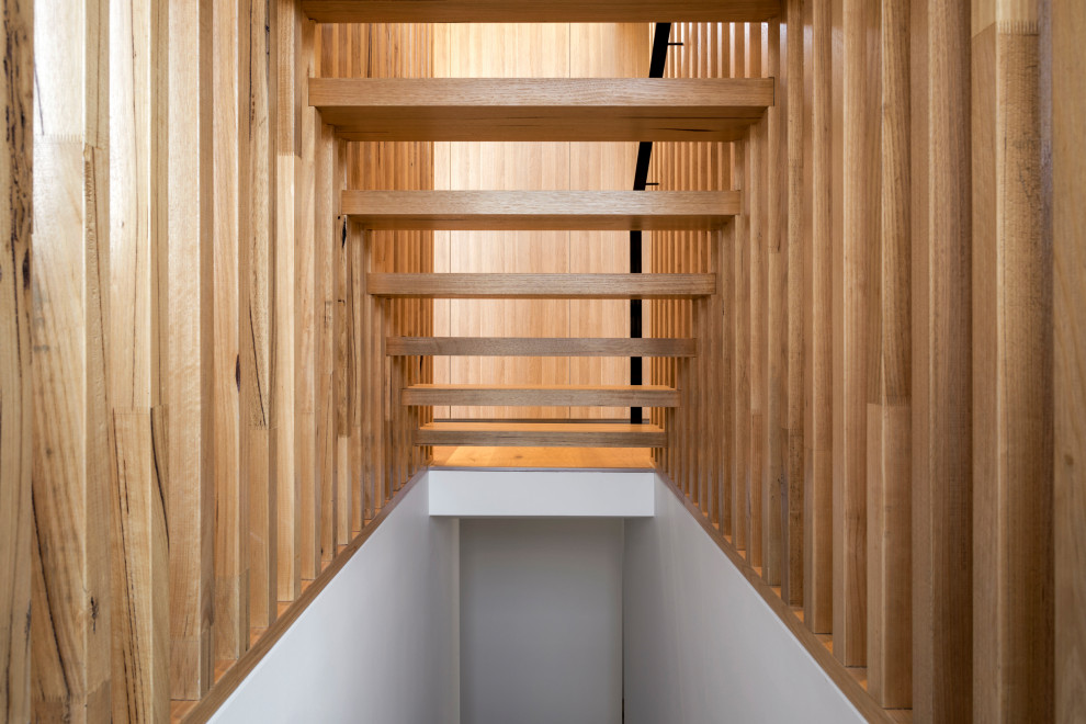 Idee per una grande scala sospesa minimal con pedata in legno, nessuna alzata, parapetto in metallo e pareti in legno