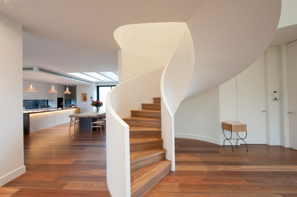 This is an example of a large wood curved staircase in Melbourne with wood risers.