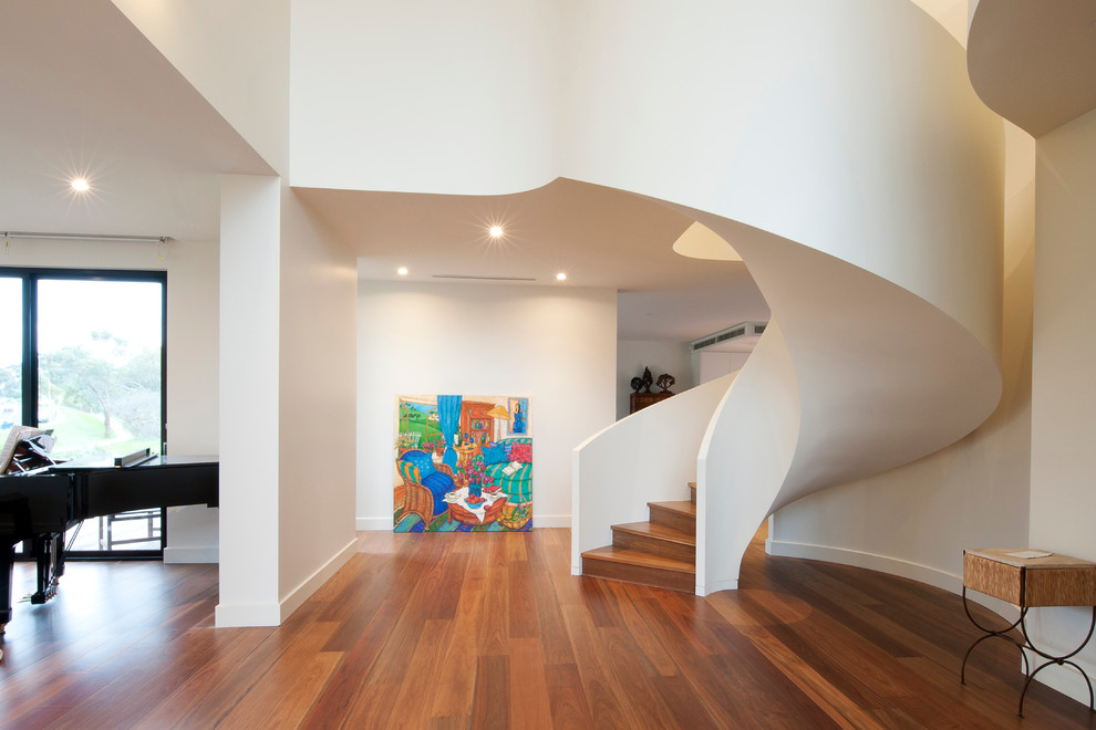 Large wood curved staircase in Melbourne with wood risers.