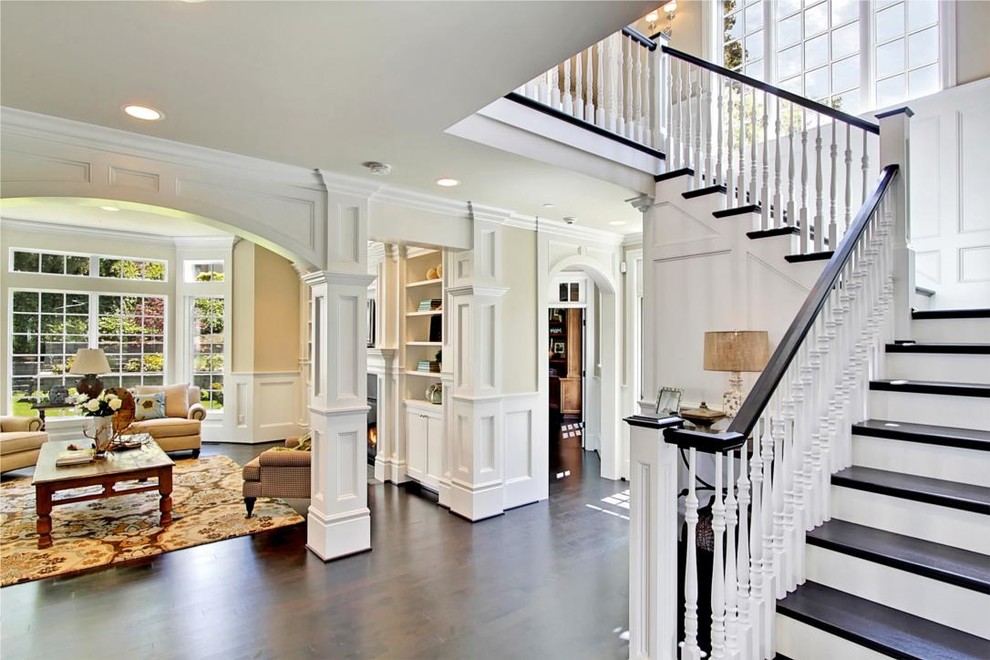 Large traditional wood l-shaped staircase in Seattle with painted wood risers and feature lighting.