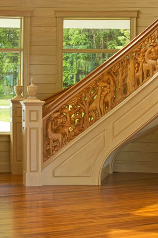 Ejemplo de escalera curva clásica grande con escalones de madera, contrahuellas de madera y barandilla de madera