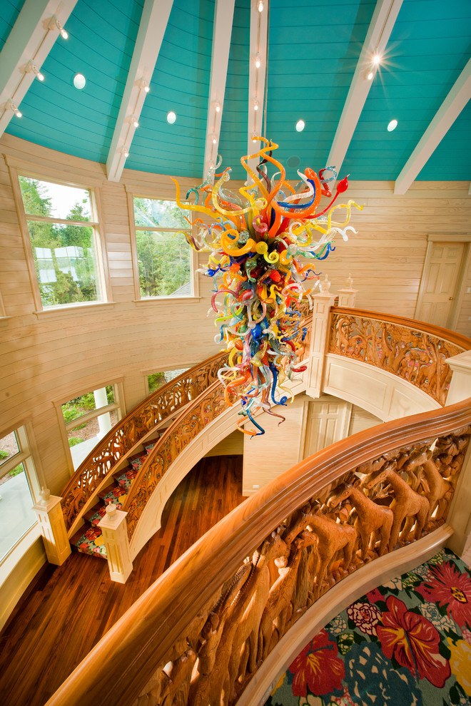 Свежая идея для дизайна: большая изогнутая лестница в стиле фьюжн с деревянными ступенями и деревянными перилами - отличное фото интерьера