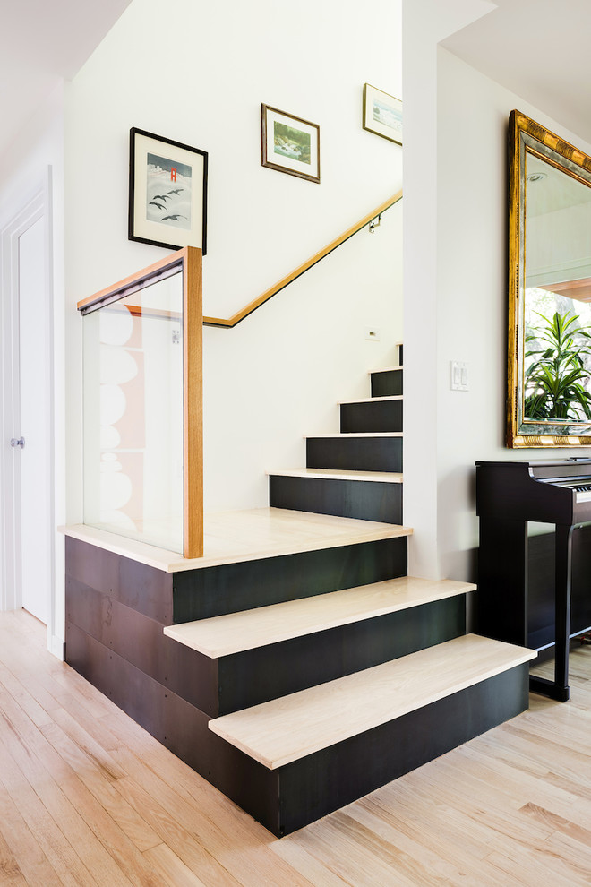 Идея дизайна: угловая металлическая лестница среднего размера в современном стиле с деревянными ступенями и стеклянными перилами
