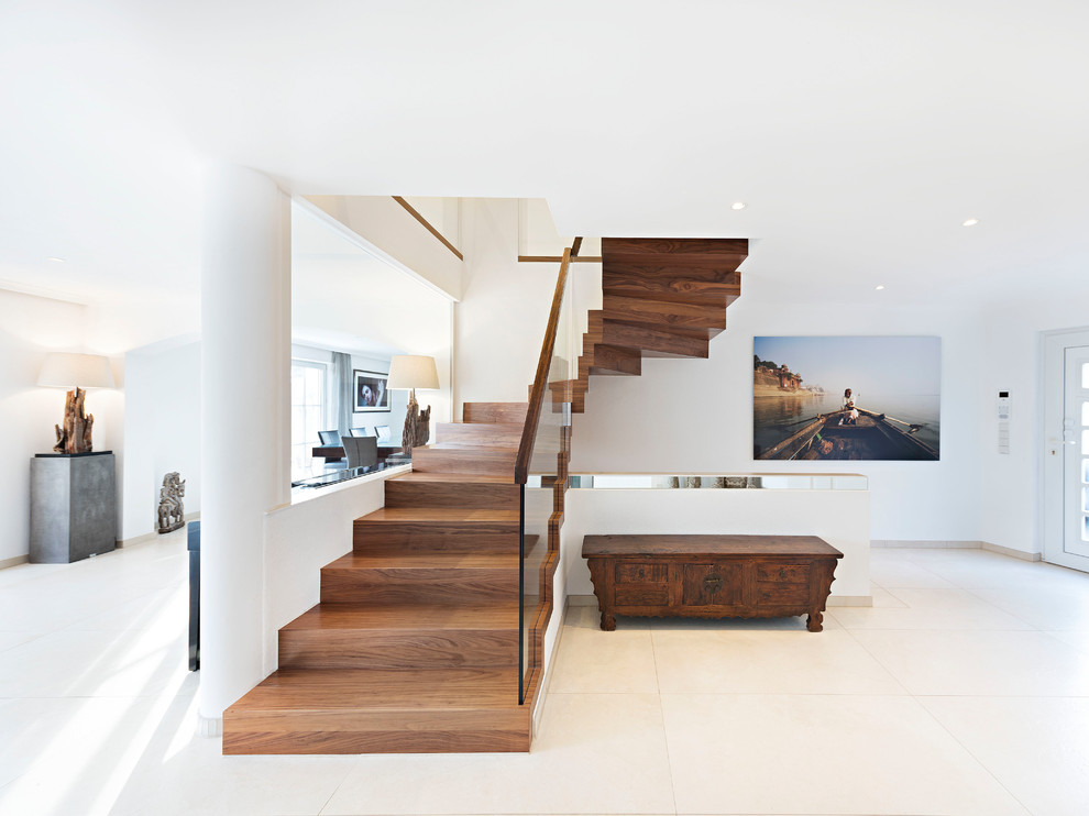 Foto de escalera en U mediterránea con escalones de madera, contrahuellas de madera y barandilla de vidrio