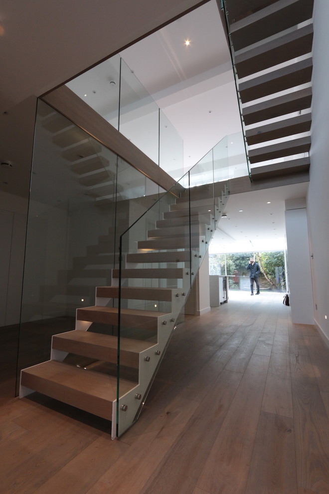Inspiration for a large contemporary wooden floating staircase remodel in London