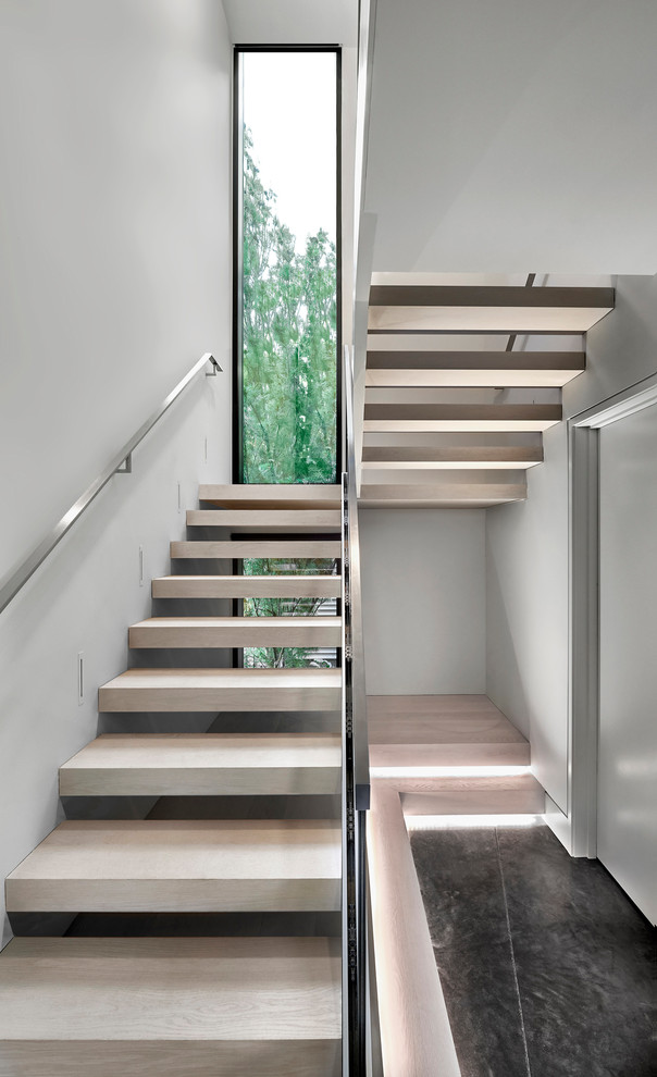 Diseño de escalera en U actual de tamaño medio sin contrahuella con escalones de madera y barandilla de metal