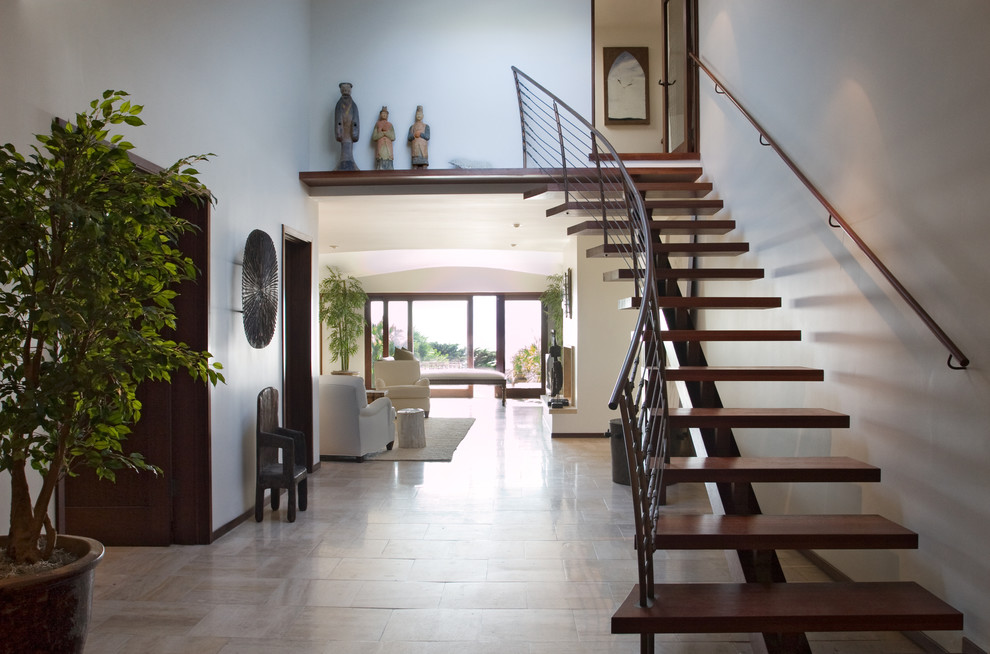 Photo of a contemporary wood curved staircase in Los Angeles with open risers.