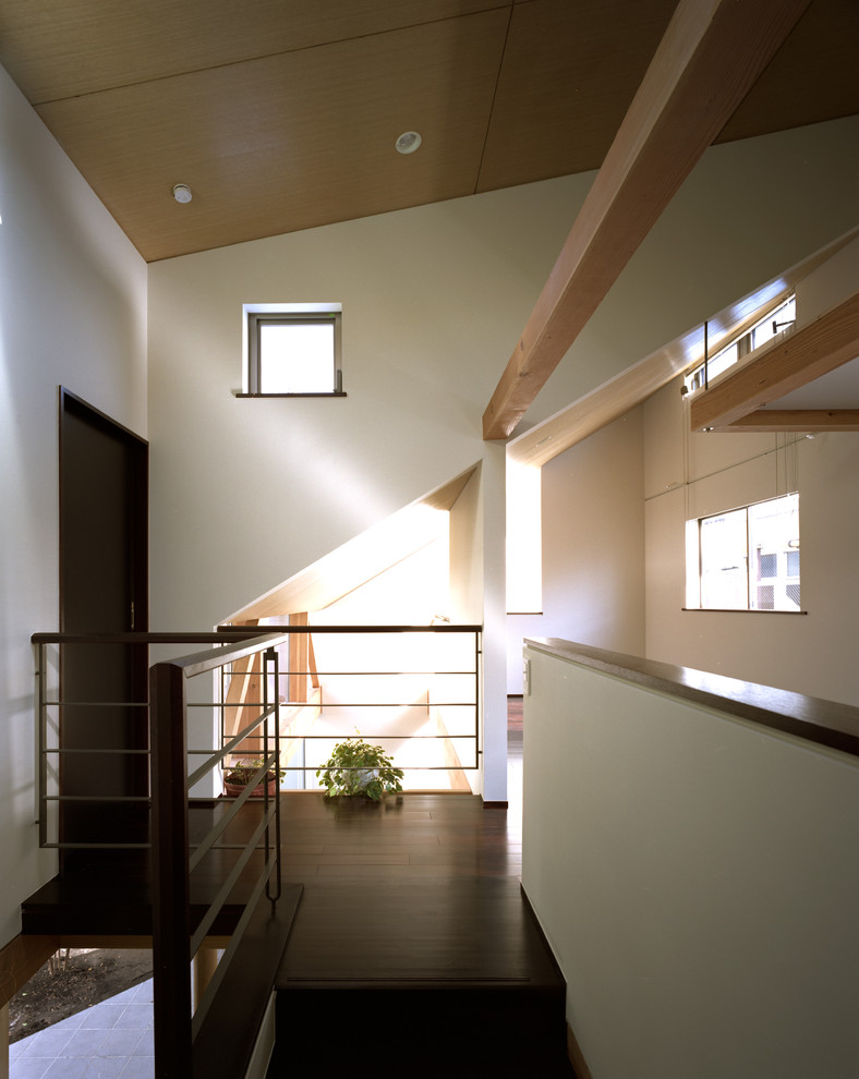 Ejemplo de escalera en U minimalista pequeña con escalones de madera, contrahuellas de madera y barandilla de metal