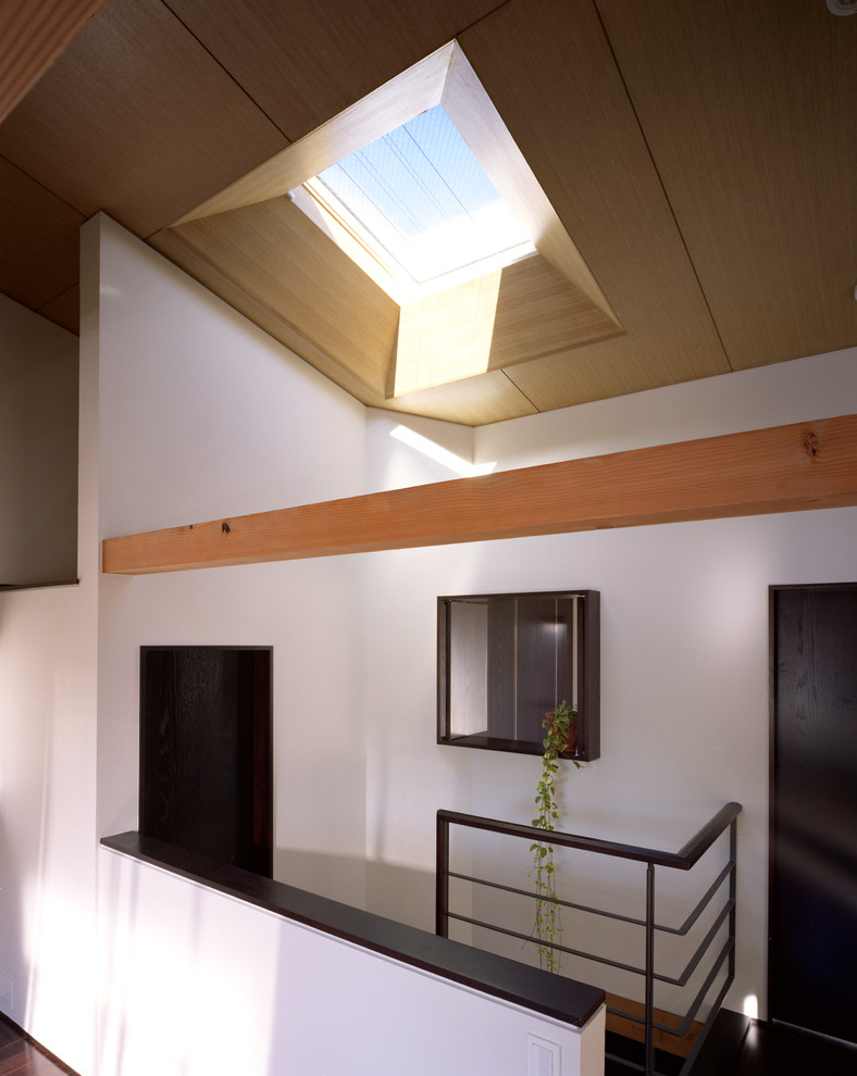 Idée de décoration pour un petit escalier minimaliste en U avec des marches en bois, des contremarches en bois et un garde-corps en métal.