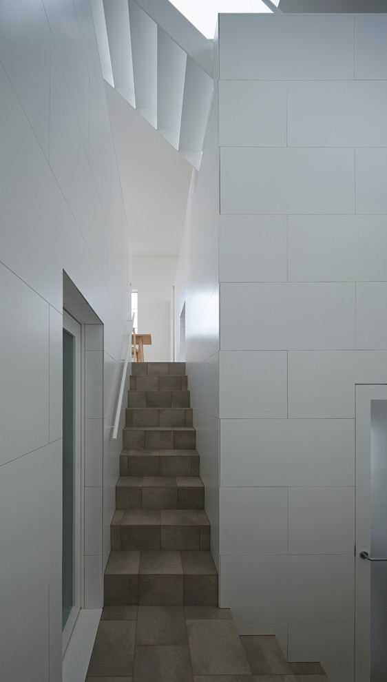 Diseño de escalera recta actual con escalones con baldosas, contrahuellas con baldosas y/o azulejos y barandilla de madera