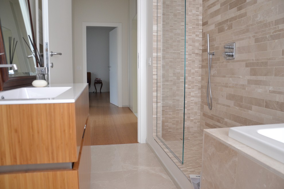 Photo of a medium sized contemporary ensuite bathroom in Rome with flat-panel cabinets, light wood cabinets, a built-in bath, a shower/bath combination, a two-piece toilet, white tiles, ceramic tiles, white walls, porcelain flooring, a built-in sink, solid surface worktops, beige floors and an open shower.