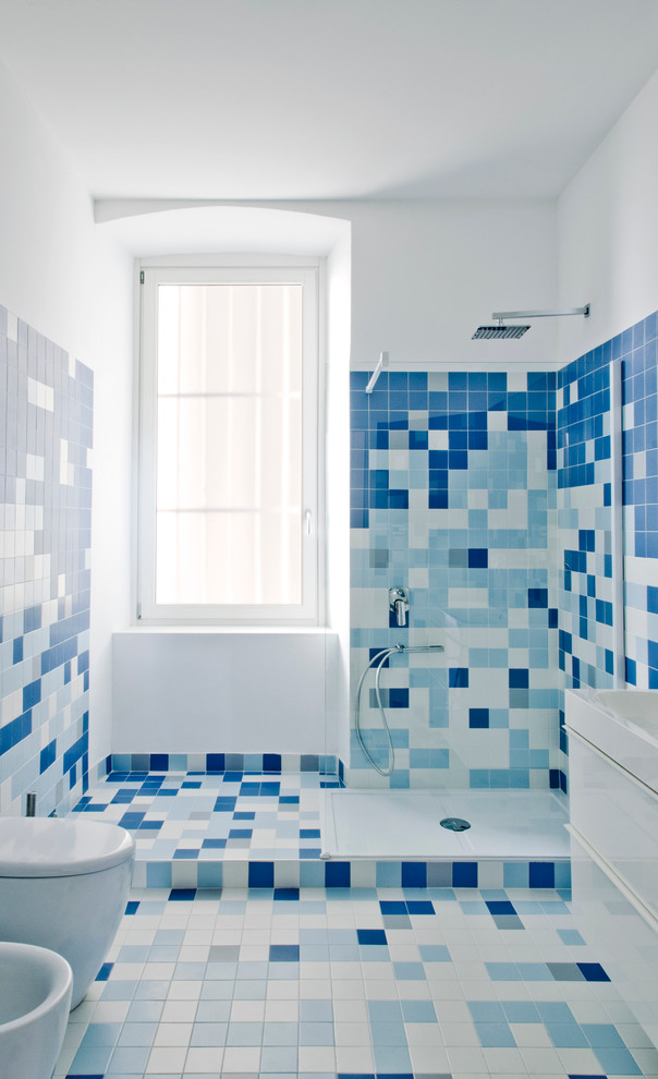 Идея дизайна: ванная комната среднего размера в современном стиле с белой плиткой, синей плиткой, керамической плиткой, душевой кабиной, открытым душем, плоскими фасадами, угловым душем, раздельным унитазом, разноцветными стенами, полом из мозаичной плитки, накладной раковиной и разноцветным полом